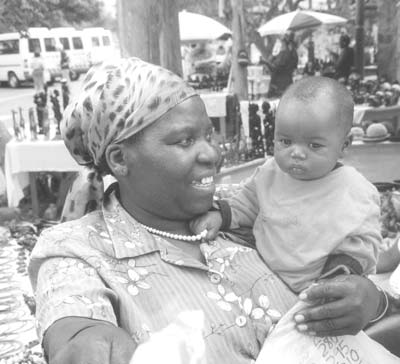 A smiling mother and her child at a roadside merchant stop in Zimbabwe.