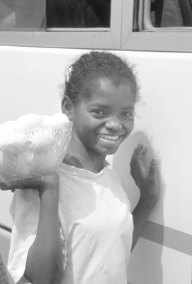 A Malagasy girl offers hard-boiled eggs for sale to bus passengers.