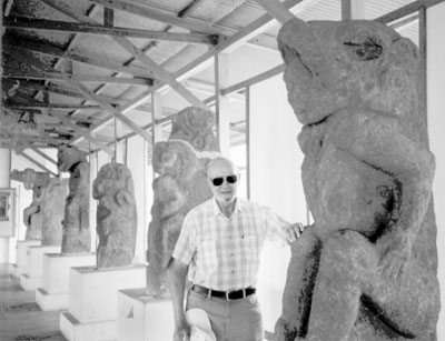 Joe Spears stands by the pre-Columbian half-man, half-beast statues at the Church of San Francisco, Granada.