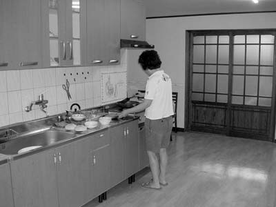 Pine cooking our breakfast in the main room of her homestay apartment. My room was through the sliding door. Photo: Graper