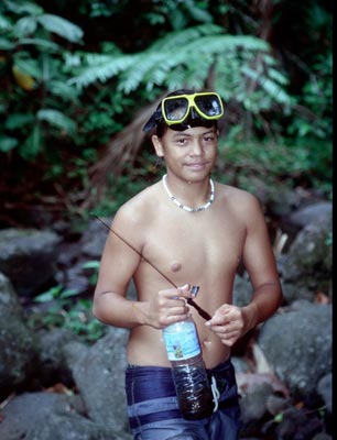 A young Tahitian fishing for crayfish.