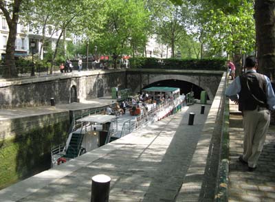 A canal boat on the Canal St. Martin enters the tunnel which takes passengers under the city.