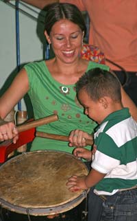 A young “wannabe” drummer gets a lesson from an experienced musician at the San Juan Cultural Center.