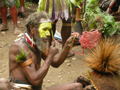 A Huli wigman from the Highlands carefully applies ceremonial face paint before donning his elaborate tribal wig.