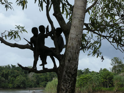 Children in a village along the Sepik River playfully welcome visitors from a high vantage point.