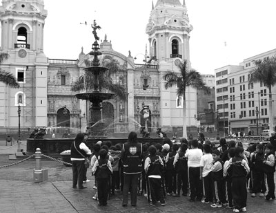 Young tourists admire the fountain in front of the 16th-century cathedral on the east side of Lima’s Plaza Mayor.