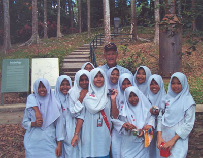 Ted Mullett posing with students visiting Sandakan Memorial Park (site of WWII Japanese POW camp) — Malaysia.