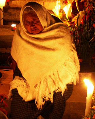 A woman sitting graveside at the cemetery in Xoxocotlán.