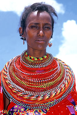 A Maasai woman wearing many necklaces made of hundreds of colorful beads — Kenya.