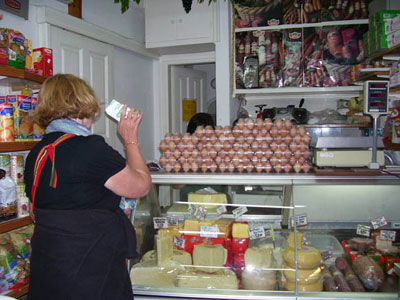 Judy visiting a food shop on Mykonos to buy local cheese and sausage.