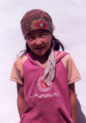 A smiling girl near Ka­-rakul Lake, one of many stops on an overland journey through the Five ’Stans.