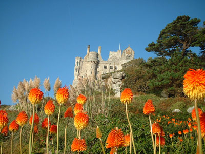 Orange-and-yellow red-hot pokers, with the castle in the background.