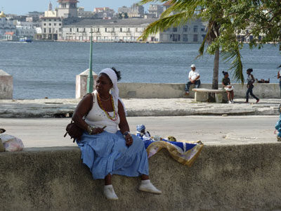The woman above is a fortune teller, stationed outside the church of the Virgen de Regla in Havana, a historic church where members practice the Christian Afro-Cuban religion called Santería. Her fee for curious tourists was five convertible pesos, the equivalent of a week’s salary in a state job or the amount a tourist might pay for two mojitos in a hotel lobby bar.