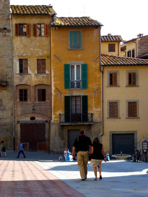 A couple walking in Arezzo’s Piazza Grande.