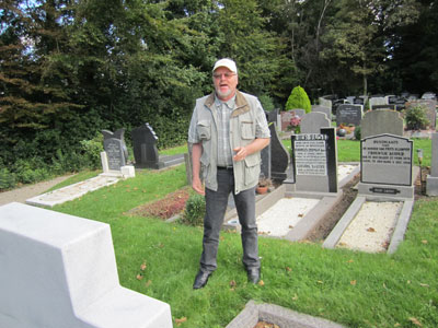 Historian Gelein Jansen standing among gravemarkers of Texel residents who were killed in reprisal by Germans in 1945. 