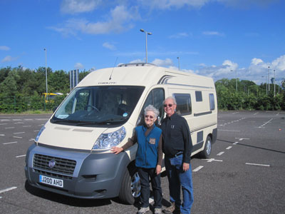 On a windy day in June near Edinburgh, Scotland, John and Margaret Graham standing next to their rented motorhome.