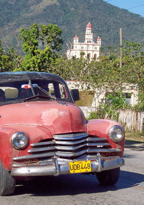 Standing outside Santiago de Cuba in southeastern Cuba were this 1947 Chevy and, in the distance, the Basílica del Cobre. Photo by Randy Keck