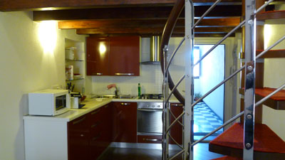 A view of the kitchen in our little apartment and the spiral staircase that led up to the loft.