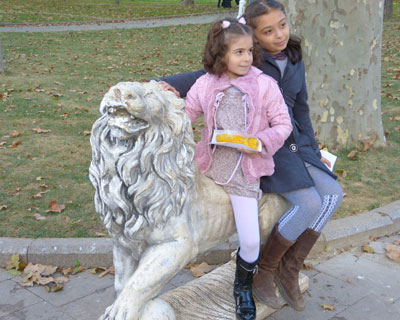 Children pose on one of the lion statues in Gülhane Park.