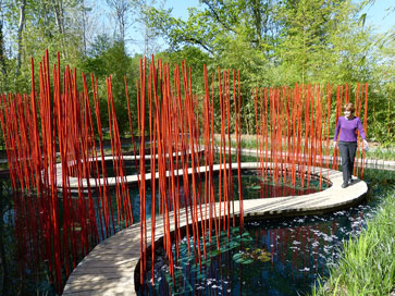 Yvonne Horn walking a boardwalk through the Japanese Garden, one of six gardens on permanent display in the Prés du Goualoup.