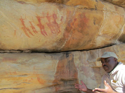 Our guide, Londi, beside a rock art painting at the Charlie Brown site.