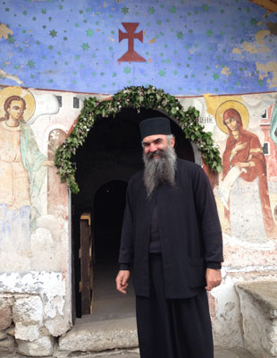 A priest in Macedonia welcomes visitors to a  hilltop chapel.