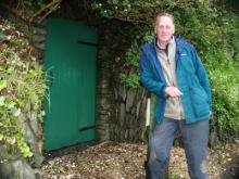 Sir Geoffrey standing near the green door to the Secret Seaside Gardens of Black