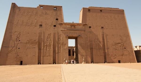 Enormous carved walls and the doorless entrance dwarf visitors to the Temple of Horus at Edfu.