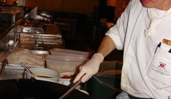 Chef Teng stirring in prawns and squid.