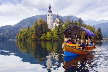 Visitors enjoy a scenic ride to a Lake Bled island on a traditional pletna boat. Photo by Cameron Hewitt