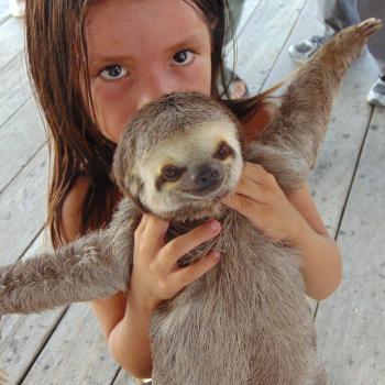A young child with a sloth whom we encountered on our river tour.
