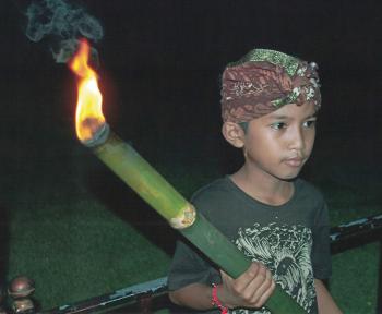 A young torchbearer leading our group to the  Taman Ayun Temple — Mengwi, Bali.