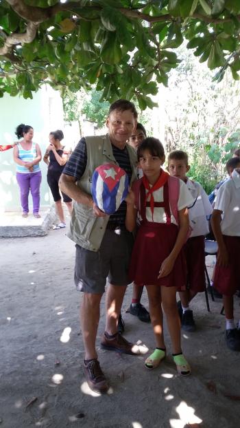 Randy holding a Cuban-flag mask made by a schoolgirl artist at an elementary school in Holguín province.