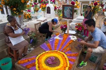 Gravesites are meticulously adorned with flowers of all colors, especially yellow and red.