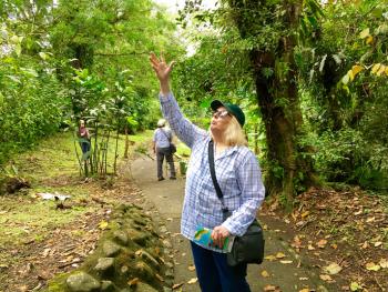 Kristine Schmidt watching monkeys in trees in Arenal Volcano National Park. Photo by Glenn Schmidt