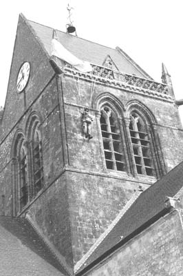 The likeness of paratrooper John Steele with his parachute caught on the church steeple in Ste-Mère-Eglise.