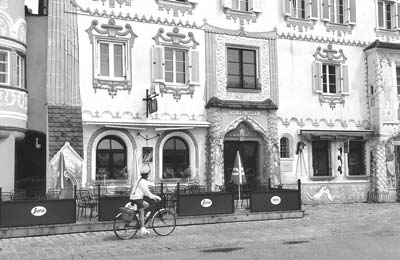 Ann Abeles rides past a Baroque building in Mauthausen, Austria.