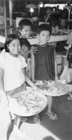 Children displaying vegetables at a local market. Photos: Keck