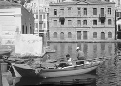 Father and son are mending fishing nets in Gialos harbor — Symi.