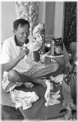 A woodcarver displays his art in the village of Mas.