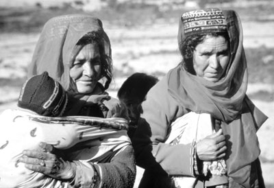 Two women, one carrying a young child, in the Hunza Valley.