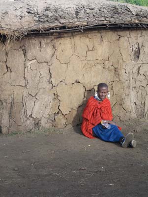 Masai woman seated beside her mud hut on the rim of Ngorongoro Crater, Tanzania.