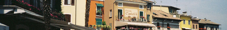 Outdoor cafés and shops surround the edge of the square in front of the moated Rocca Saligera castle, a popular tourist stop in Sirmione, Lake Garda.