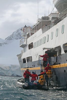 Passengers stepping from a Zodiac back onto the M/S Andrea.