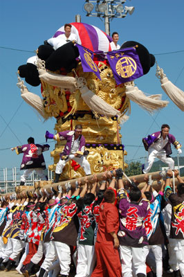 Men hoisting and moving a taikodai during the Niihama Taiko Festival — Funaki Elementary School.