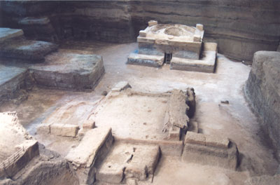 Joya de Cerén with sweat house in background and house foundation in foreground. Note layers of volcanic ash behind sweat house.