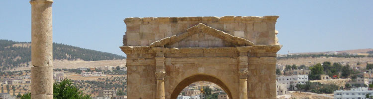Entrance arch with columns leading down both sides of the street in Jerash, Jordan.