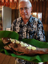 John Scott with the fish on a banana leaf ready to place on the charcoal broiler.