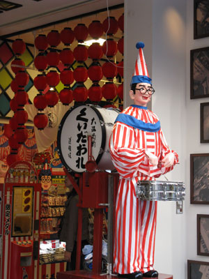 This life-size mechanical figure of a drum-playing clown, the advertising symbol of Kuidaore Ningyo, is a popular spot to take a picture at the Dotonbori shopping street in Osaka.