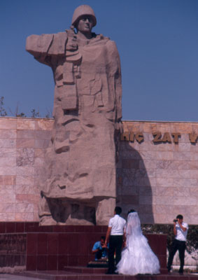 A couple having wedding photos taken at Ashkha­bad’s WWII Memorial.